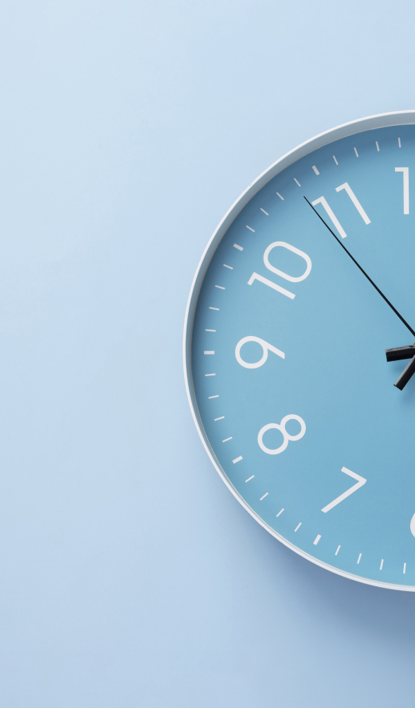 Круглые часы на голубом фоне крупным планом