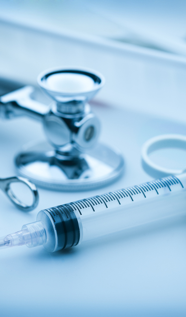 Шприц, зажим  и стетоскоп на столе