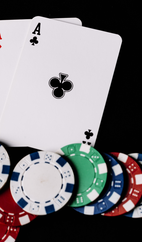 Два туза и фишки для покера  на черном фоне