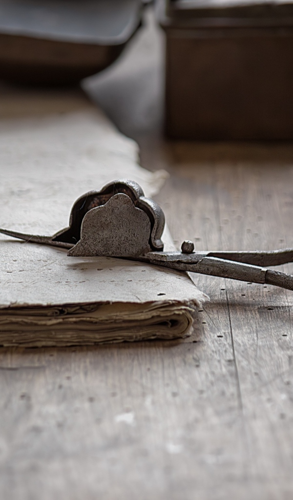 Старинные железные ножницы с бумагой на столе