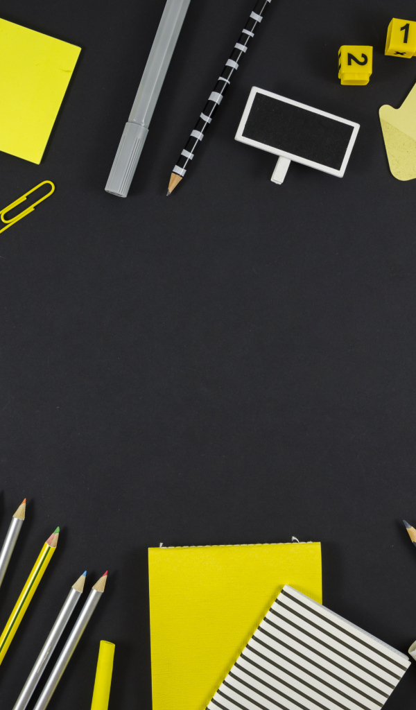 Желтые разные канцелярские предметы на черной поверхности 