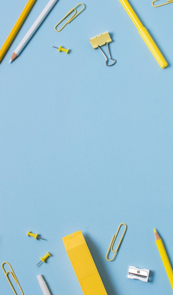 Желтые канцелярские предметы на голубом столе
