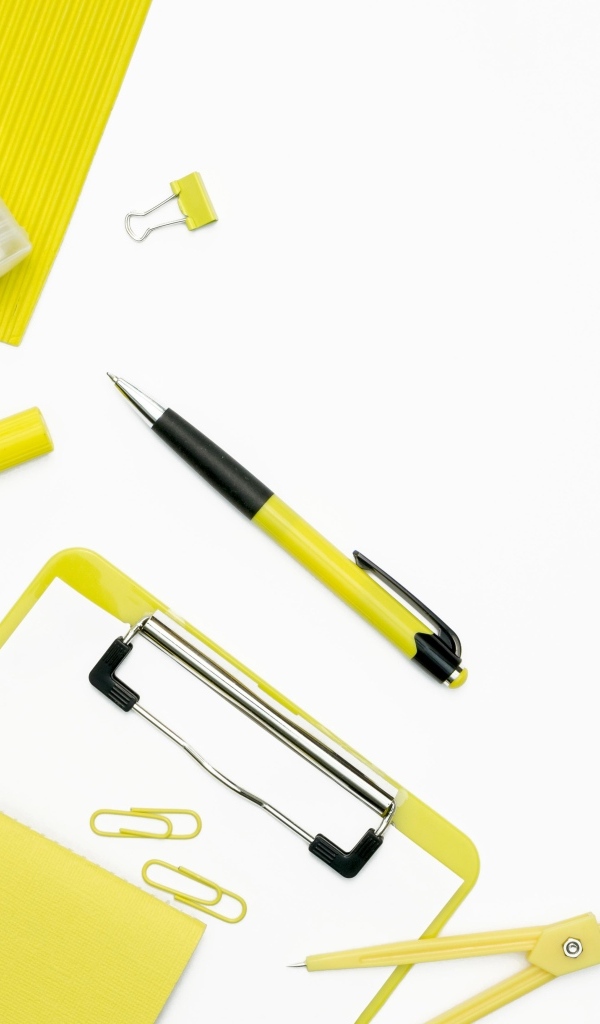 Желтые канцелярские предметы на белом фоне