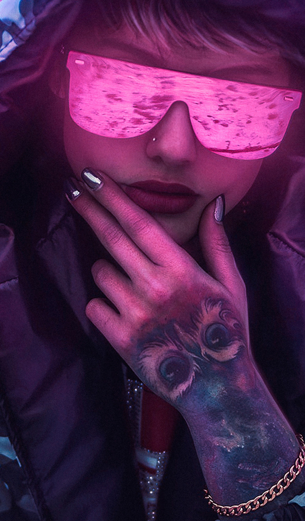 Девушка в неоновых очках с татуировкой на руке