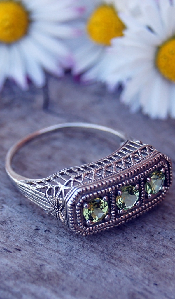 Старинный перстень на столе с ромашками