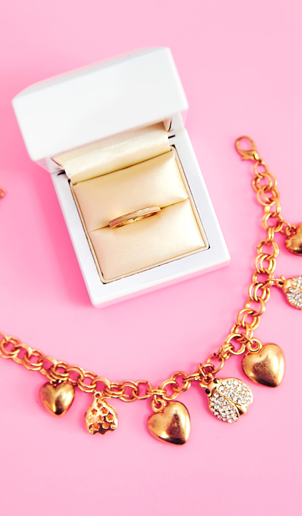 Браслет и кольцо в коробке на розовом фоне