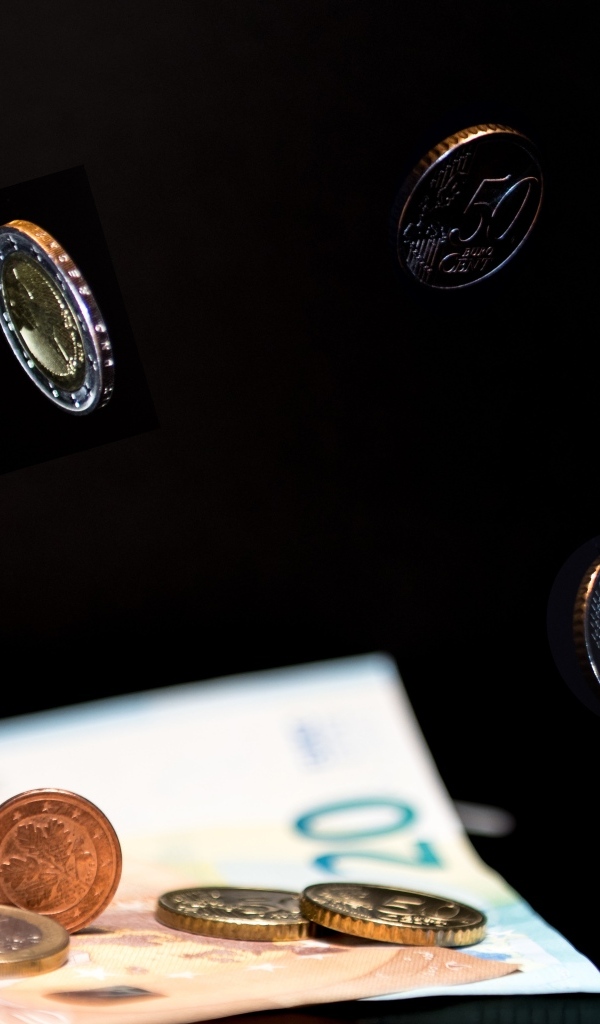 Купюры с монетами на черном фоне