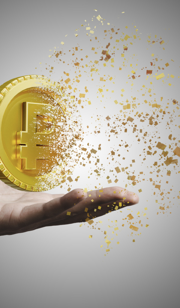 Монета разрушается на ладони на сером фоне