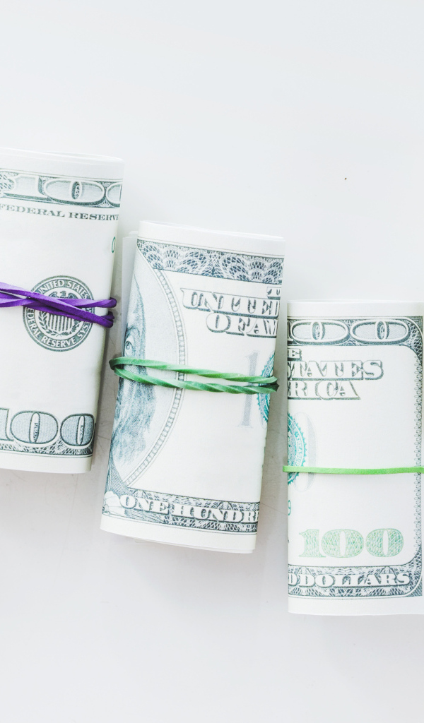 Свертки с долларами на сером фоне