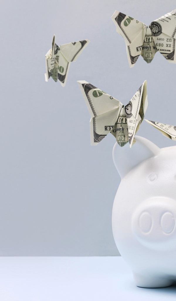 Свинья копилка с бабочками из купюр на сером фоне