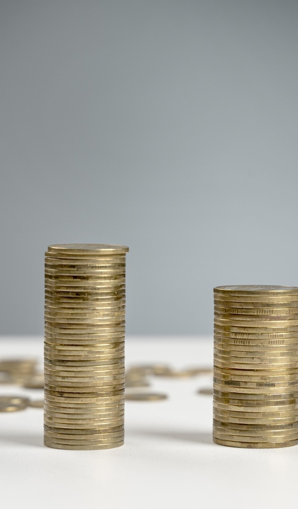 Стопки монет на сером фоне на столе