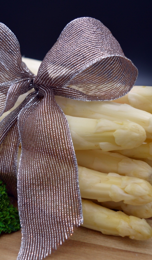 Спаржа с бантом на столе с петрушкой