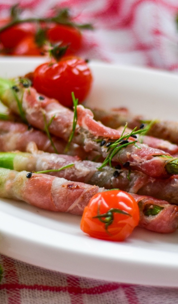 Спаржа в беконе на тарелке с вареными яйцами