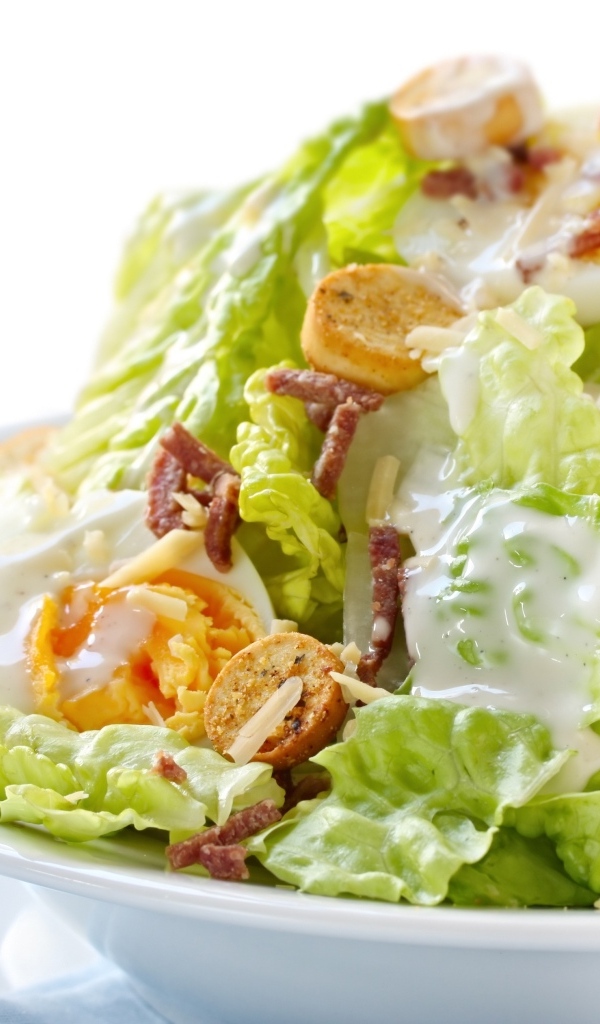 Салат Цезарь на большой белой тарелке