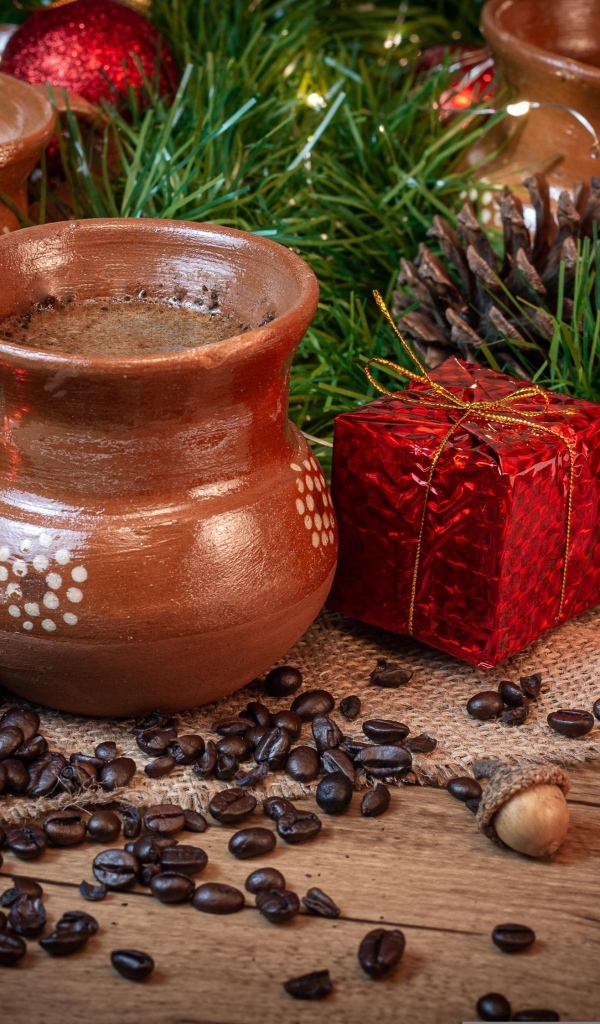 Кофейные зерна на столе с посудой и еловой веткой