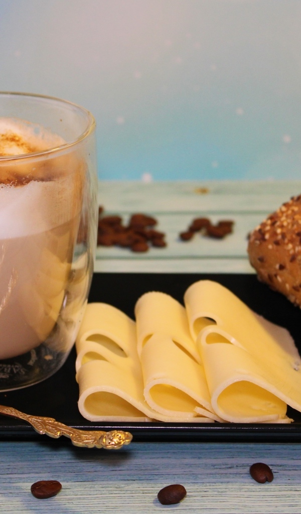 Кофе на тарелке с булочкой и кусочками сыра