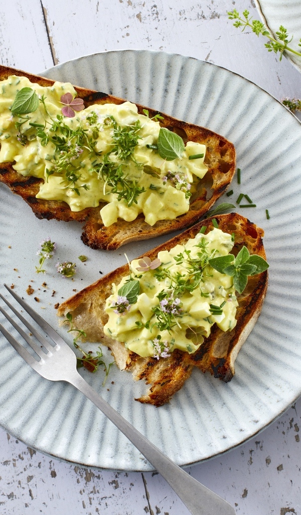 Гренки с кремом и зеленью на тарелке