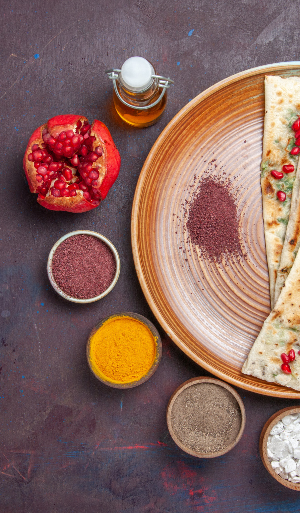 Лепешки на столе со специями и зеленью