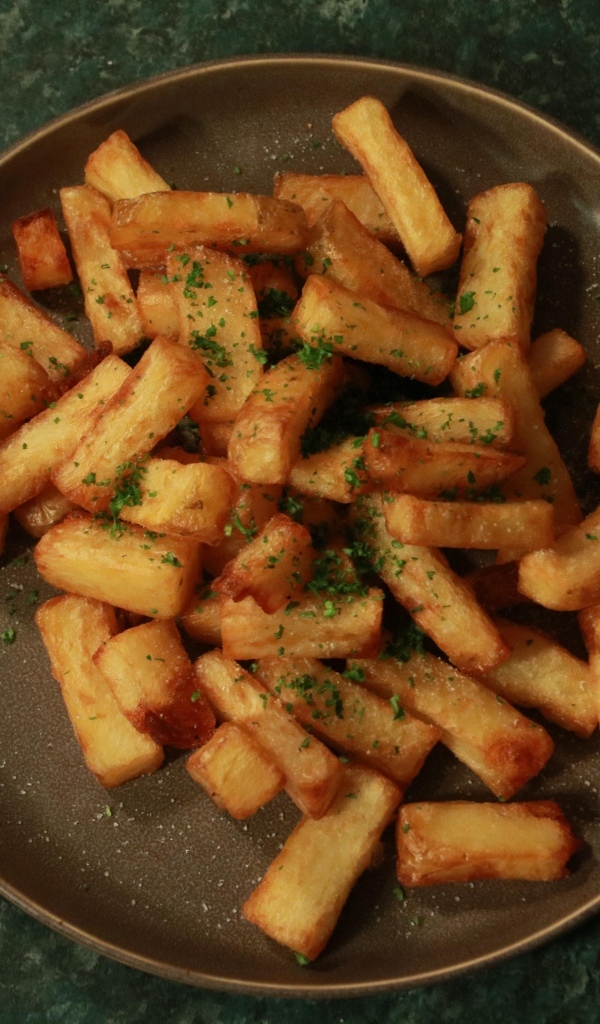 Картофель фри на большой тарелке на столе