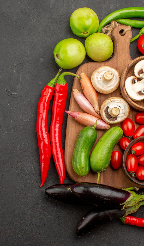 Свежие овощи на разделочной доске на столе