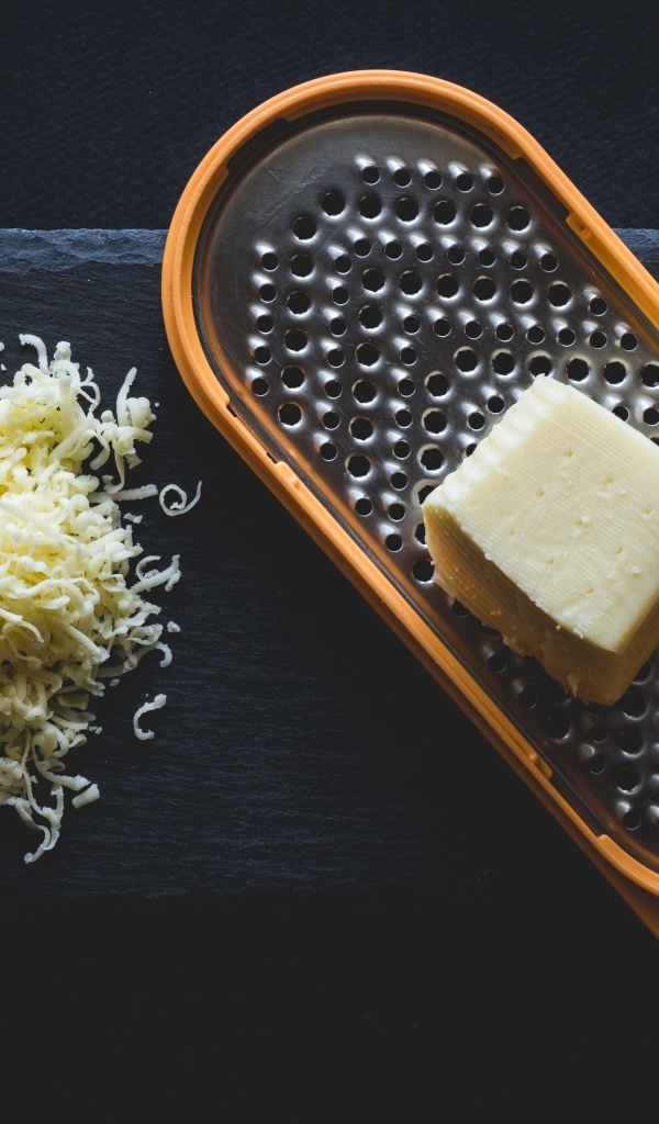 Тертый сыр на черном столе