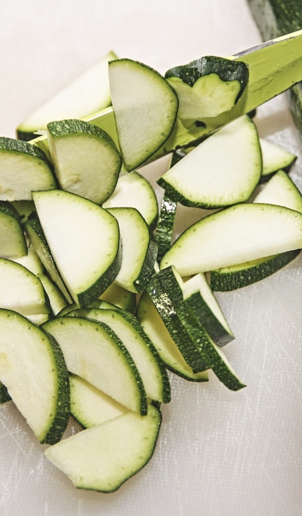 Зеленый кабачок цуккини нарезан на столе