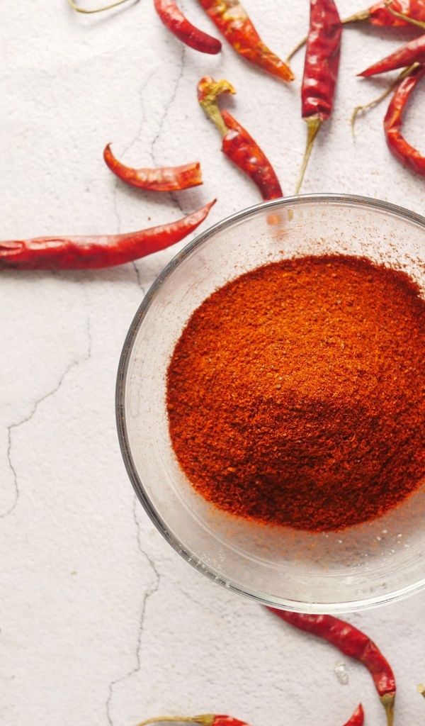 Молотый жгучий красный перец на столе