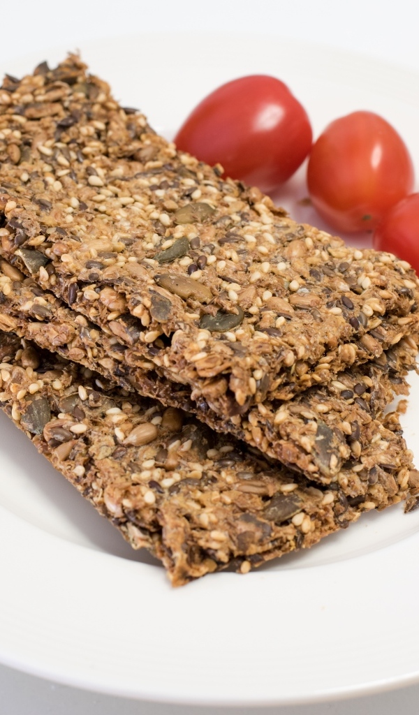 Полезны злаковые хлебцы на тарелке с помидорами