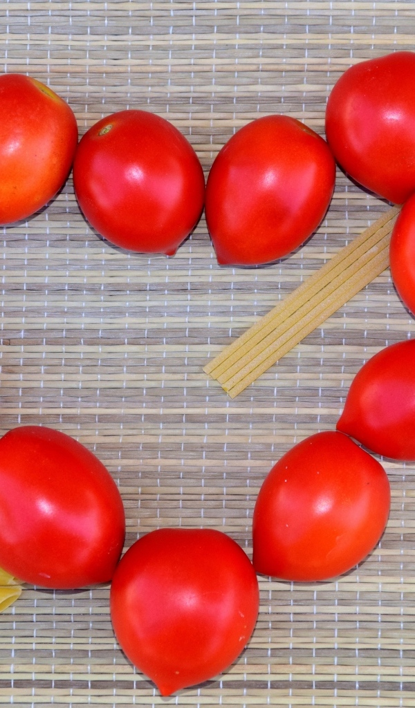 Сердце из помидоров на столе с макаронами