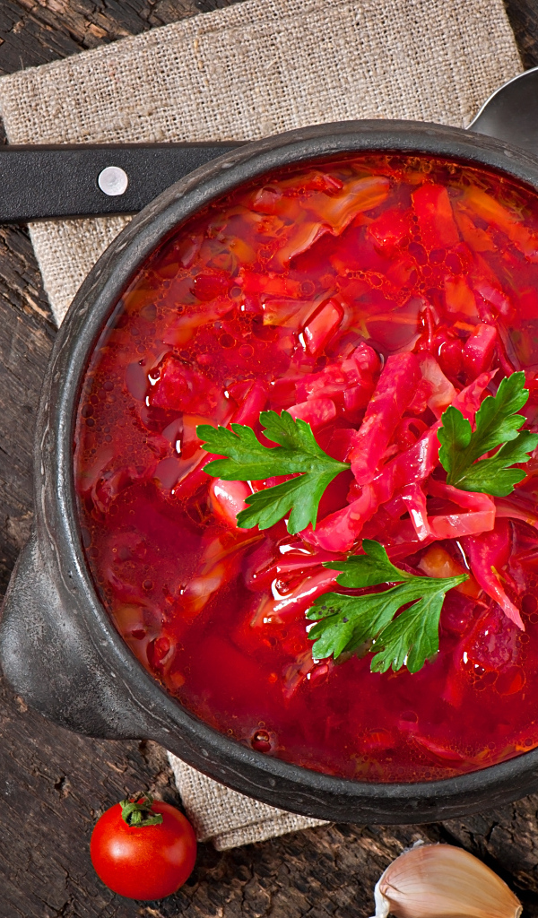 Большая тарелка красного борща на столе