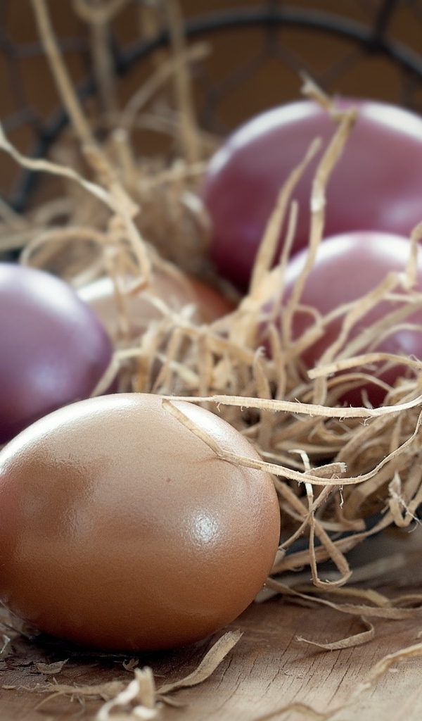 Разноцветные яйца на столе с сеном