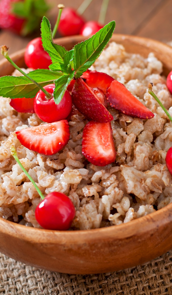 Овсяная каша с ягодами в деревянной миске