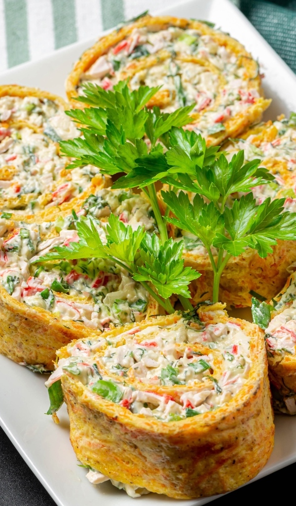 Рулет с омлета с начинкой на тарелке