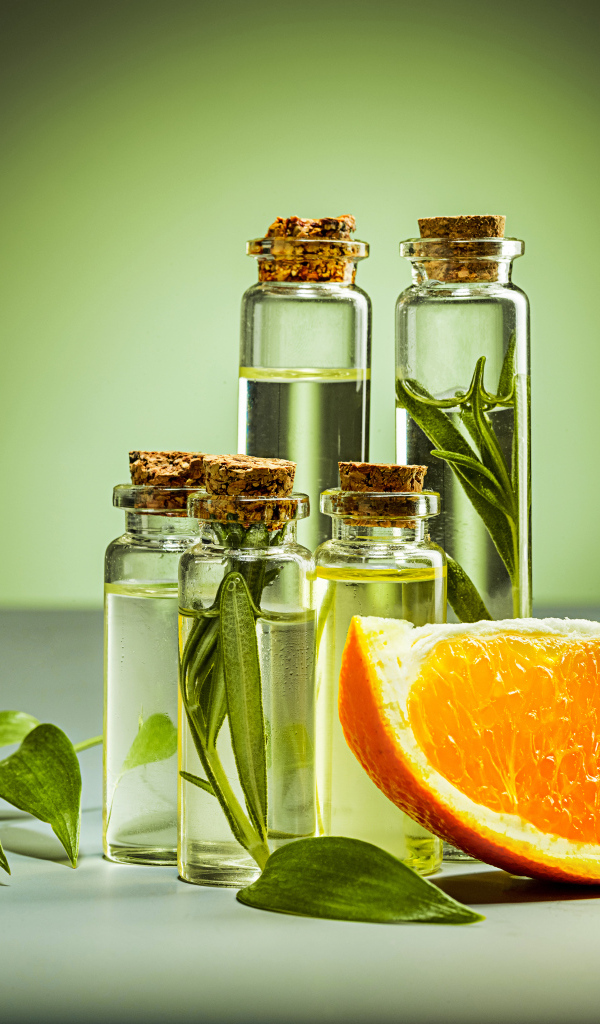 Апельсиновое масло на зеленом фоне с апельсинами