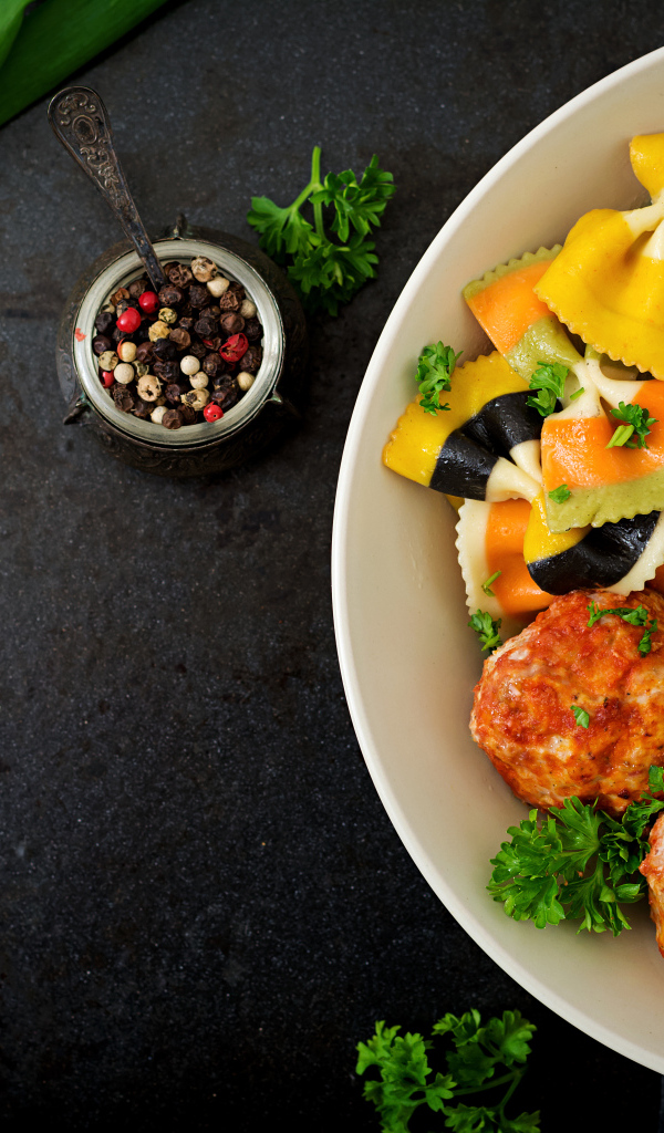 Паста с тефтелями и салатом в тарелке