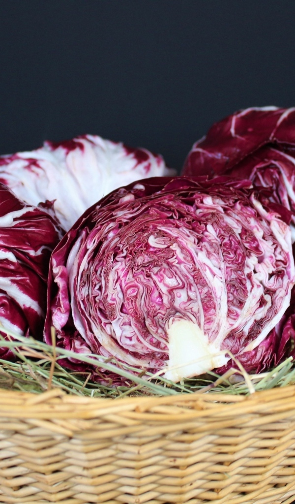 Красная капуста в корзине на черном фоне