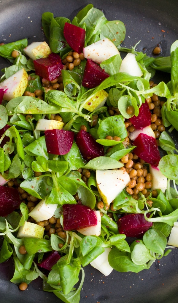 Салат с зеленью в большой черной тарелке