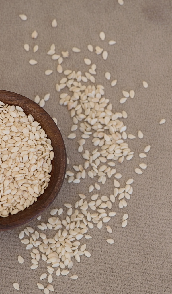 Зерна кунжута в деревянной миске на столе