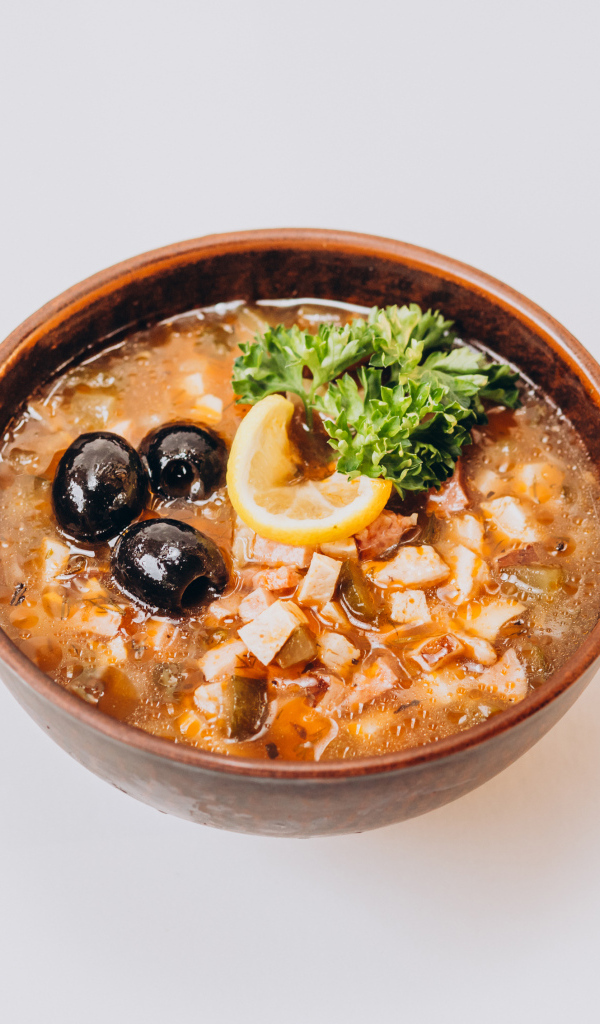 Солянка в тарелке на сером фоне