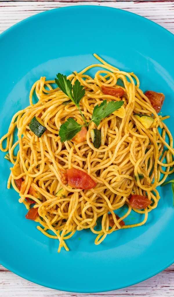 Спагетти с овощами  на голубой тарелке