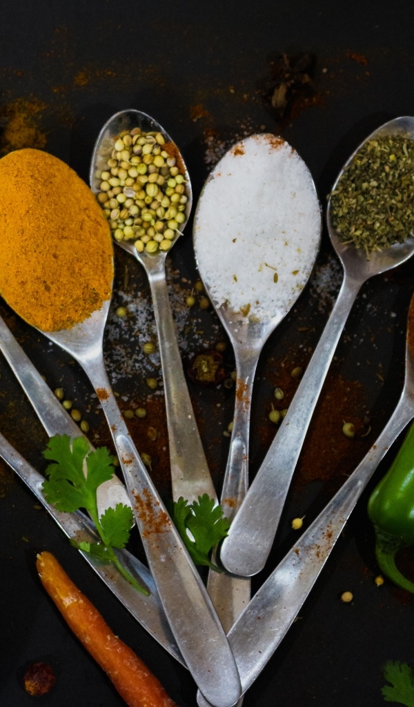 Ложки с ароматными специями на черном столе