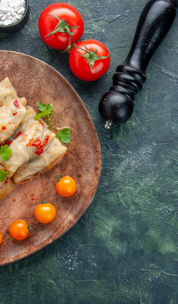 Голубцы на столе с помидорами и специями