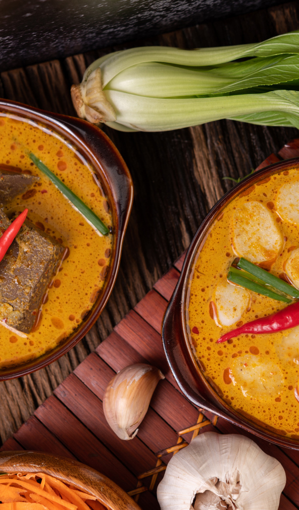 Две тарелки с острым супом на столе