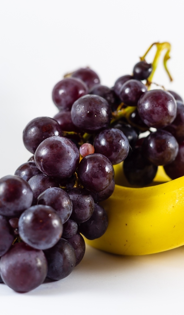Гроздь винограда с бананами на столе