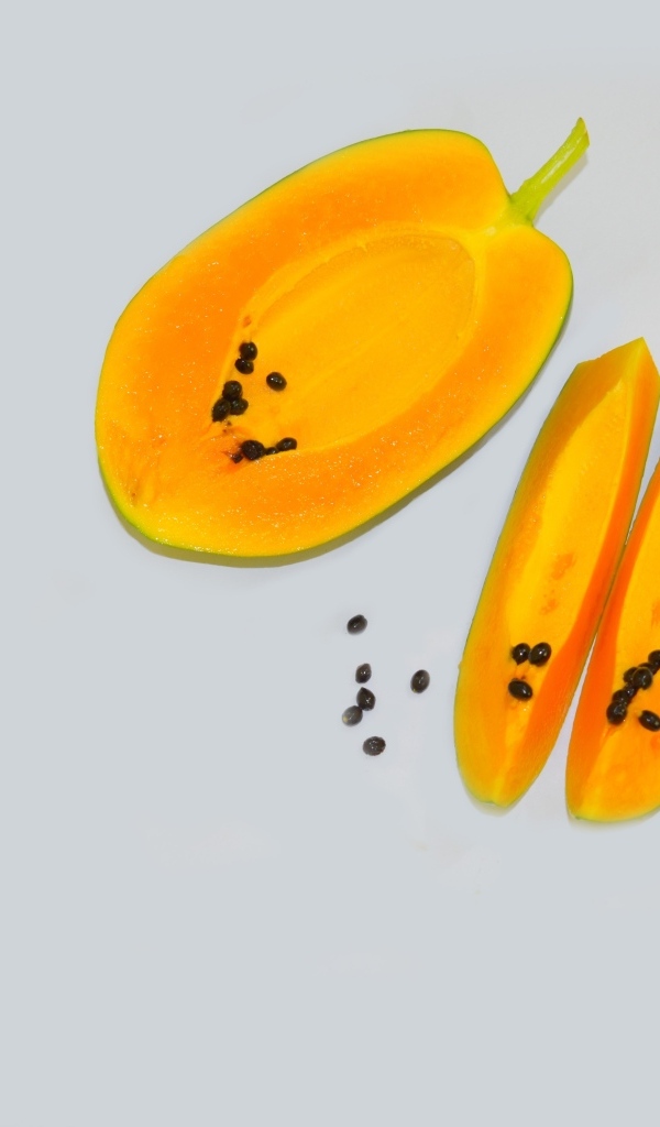 Разрезанная папайя на сером фоне