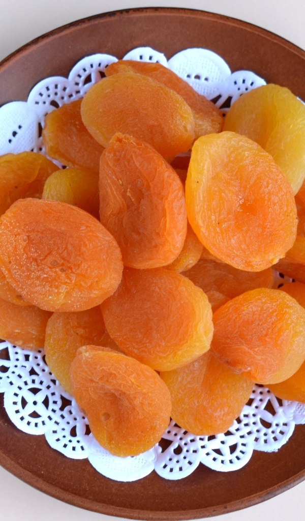 Курага с тарелке на сером фоне