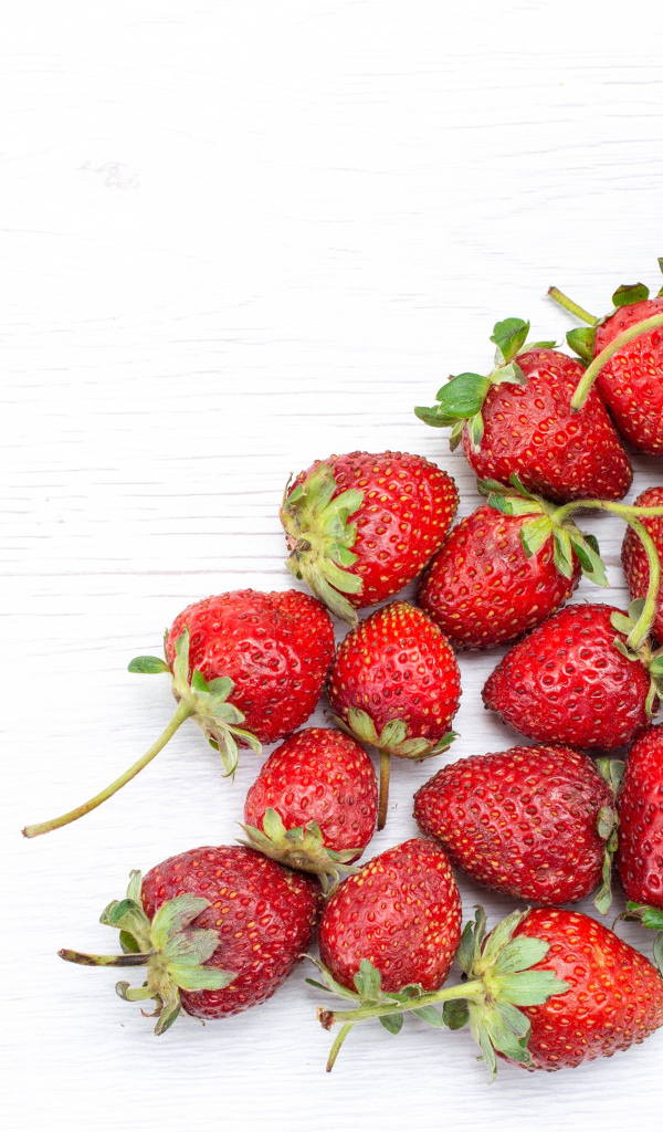 Стеклянный стакан с ягодами клубники на столе