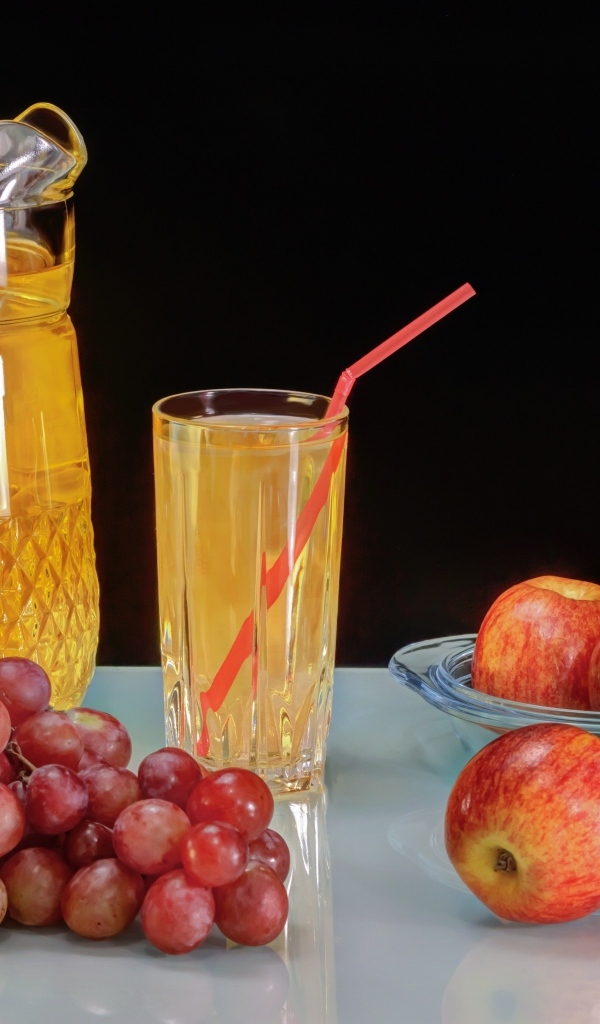 Виноград и яблоки на столе с соком