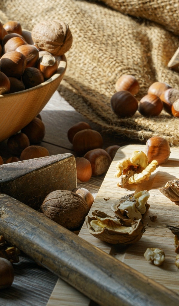 Фундук и грецкие орехи на столе с молотком