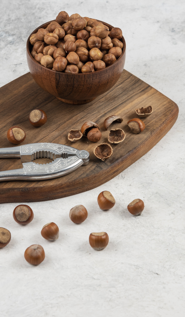 Лесные орехи на сером столе с разделочной доской
